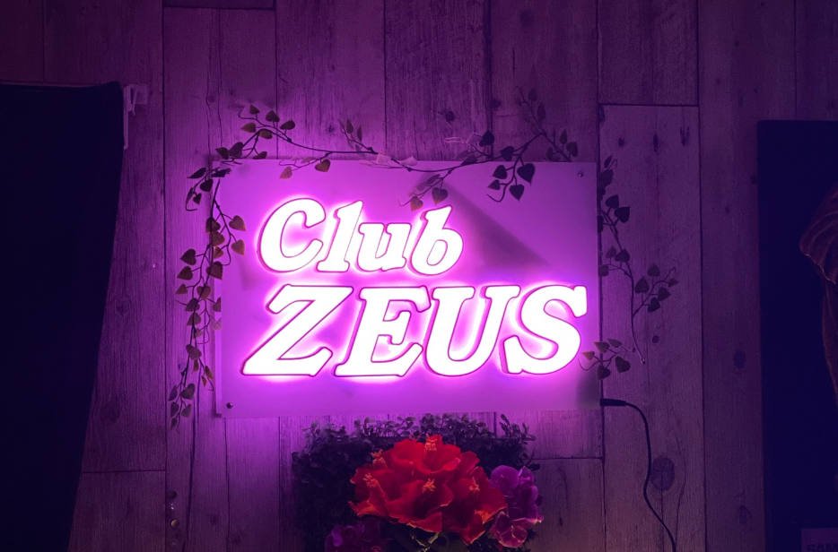 受付を終えて、入ったら左がカウンター、右は壁になっていて、そこにネオン輝く幻想的なゼウスの看板がある。