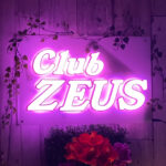 受付を終えて、入ったら左がカウンター、右は壁になっていて、そこにネオン輝く幻想的なゼウスの看板がある。