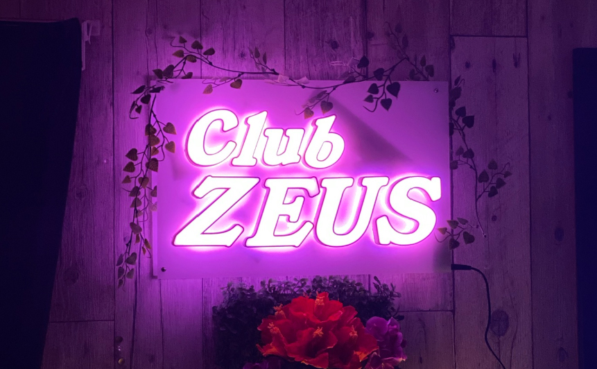 受付を終えて、入ったら左がカウンター、右は壁になっていて、そこにネオン輝く幻想的なゼウスの看板がある。